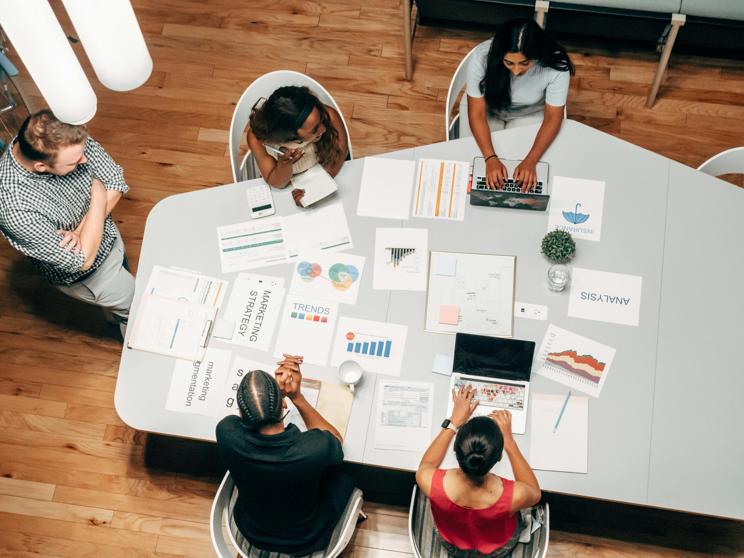 5 people working around a table in an office